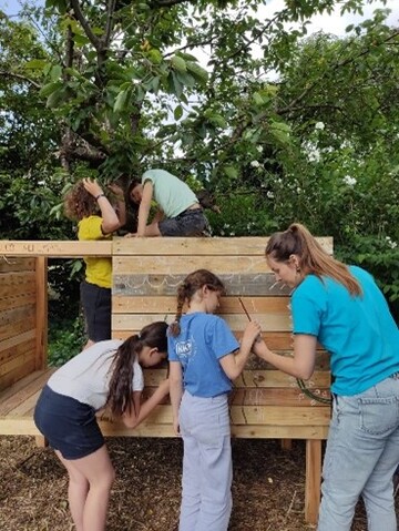 Kinderen werken aan de speelhutjes.