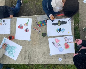 Kinderen werken schetsen uit voor de muurtekening